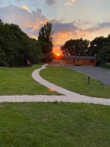 un sentiero ghiaioso in un campo con il tramonto sullo sfondo di Fox Lodge at Owlet Hideaway - with Hot Tub, Near York a York