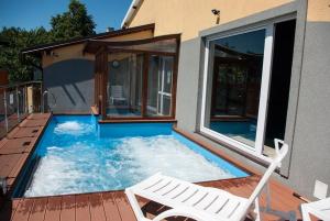a small swimming pool with two white chairs and avisor at Sanatorium Fala in Stegna