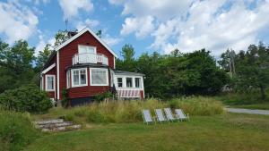 a red house with two chairs in front of it at Villa Nyborg - By the Sea in Stockholm