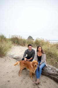 a woman and a dog on a beach at Inn at Haystack Rock in Cannon Beach