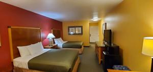 a small hotel room with a bed and a tv at Olympic View Inn in Sequim