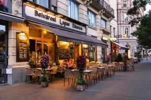 a group of tables and chairs in front of a restaurant at Helena apartment with view on St. Stephan's Basilica in Budapest