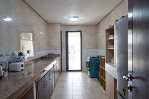 a large kitchen with a sink and a hallway at Seddo Apartments in Abidjan