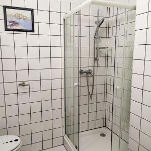 y baño con ducha y puerta de cristal. en Sirály apartman en Keszthely