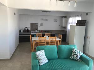 a living room with a green couch and a kitchen at Vistas Meseta Patagónica II in Trelew