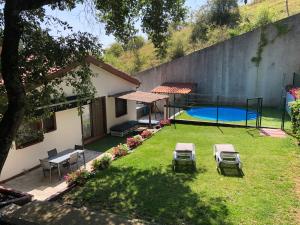 un patio trasero de una casa con piscina en Casa rural completa en plena naturaleza, en Eguíllor