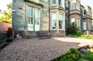 a house with two chairs and a bench in front of it at House on the hill in Dundee