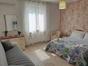 um quarto com uma cama e um sofá em B&B Villa Rosa em SantʼAntonio Abate