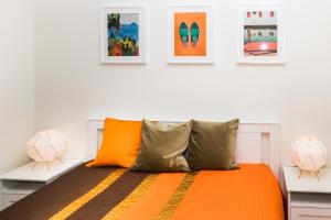 a bedroom with an orange bed with two lamps at Favorite apartment Elija, Sventoji in Šventoji