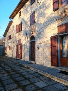 un antiguo edificio de piedra con puertas de madera en una calle en La Giuncaia en Pieve Santo Stefano