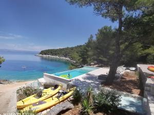 a group of yellow kayaks on a beach next to a pool at Holiday house Karla in Vela Luka