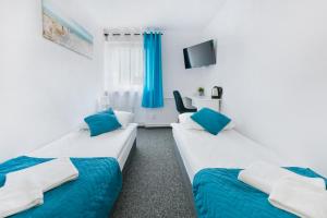 a room with two beds and a tv at Przyjaciół 13 in Mielno