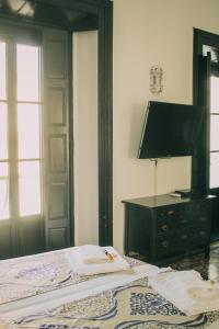 タリファにあるLa Duquesa Guest Houseのベッドルーム1室(ランプとドレッサー付きのベッド1台付)