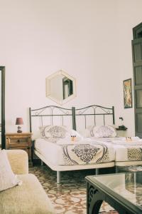 タリファにあるLa Duquesa Guest Houseのベッド2台(壁に鏡付)が備わるベッドルーム1室