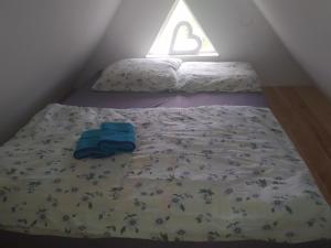 a bed in a small room with a blanket and a pillow at Agrowczasy u Bartka in Wielki Klińcz