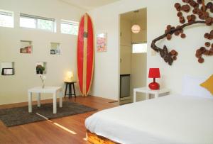 a bedroom with a bed and a surfboard on the wall at 墾丁南灣浪人名宿包棟 in Nanwan