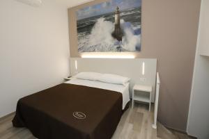 a bedroom with a bed and a painting on the wall at Orchidea Rooms & Suites in Civitanova Marche