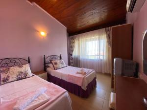a bedroom with two beds and a television in it at Maviev Otel in Çeşme