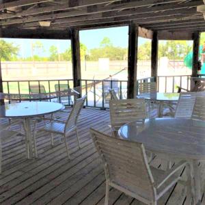 un groupe de tables et de chaises sur une terrasse dans l'établissement Village by the Gulf, à Gulf Shores