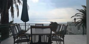 una mesa y sillas en un balcón con vistas al océano en Apartments Tri Palme, en Baška Voda