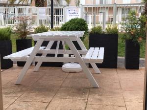 una mesa de picnic y un banco en un patio en RESIDENCE LA CROISIERE- Appt Duplex 6 Personnes, en Anglet