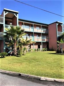 a large apartment building with a lawn in front of it at Village by the Gulf in Gulf Shores