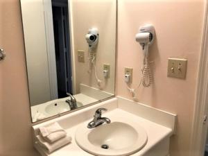a bathroom with a sink and a mirror and a phone at Village by the Gulf in Gulf Shores