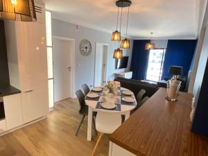 a kitchen and living room with a table and chairs at Apartament SZAFIROWY Gardenia Dziwnów z widokiem na morze in Dziwnów