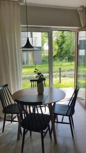 a dining room table with two chairs and a potted plant at APARTAMENT Marina Port in Wrocław