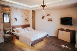 a bedroom with a bed and a brick wall at Villa Amfora in Ohrid