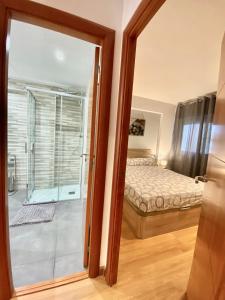 1 dormitorio con 1 cama y puerta corredera de cristal en Ridaura Center Apartment, en Platja d'Aro