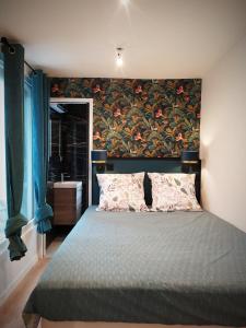 a bedroom with a large bed with a floral wall at PARADISE sur Mer, Terrasse, Spa,Proximité Nausicaa, Plage, Restaurants in Boulogne-sur-Mer
