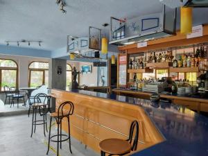 ein Restaurant mit einer Bar mit Hockern in der Unterkunft Hotel Villa in Isla