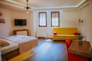 a bedroom with a bed and a yellow couch at Villa Amfora in Ohrid