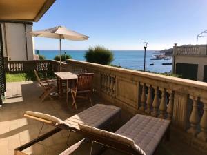 a balcony with a table and chairs and an umbrella at Appartamenti fronte mare in Castiglioncello