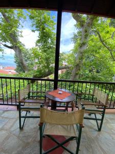 una mesa y sillas en un balcón con vistas en Petrino, en Palaios Panteleimon