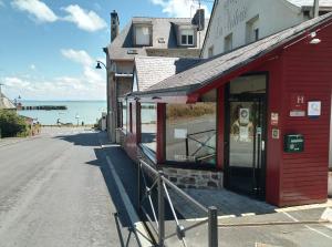 a red brick building with a sign on the side of it at Hotel La Voilerie Cancale bord de mer in Cancale