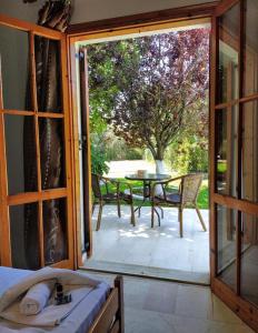 an open door to a patio with a table and chairs at Filoxenia Apartments in Riza