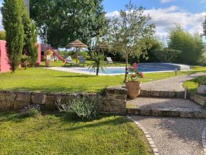 a backyard with a swimming pool and a garden at Les Marguerites in Champdolent