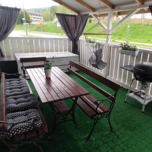 a patio with a wooden table and chairs and a grill at Apartament Deja Vu-Bieszczady in Ustrzyki Dolne