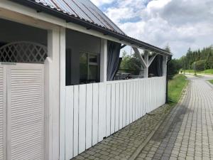 a house with a white fence and a gate at Apartament Deja Vu-Bieszczady in Ustrzyki Dolne