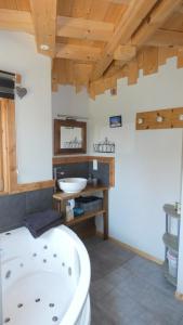 a bathroom with a white tub and a sink at Chalet la Petite Perle in Gérardmer
