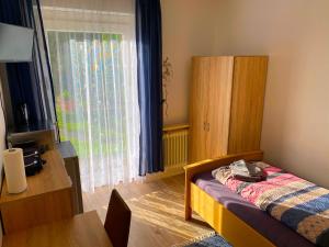 1 dormitorio con cama, mesa y ventana en Ferienwohnung Fischach, en Fischach