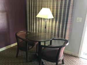 una mesa y dos sillas y una lámpara en una habitación de hotel en Silver Princess Motel, en Ocala