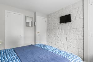 1 dormitorio con cama y pared de piedra en Aynetree Guest House en Edimburgo