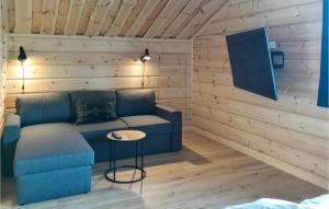 a living room with a blue couch and a table at Gorgeous Home In Vemdalen With Sauna in Vemdalen