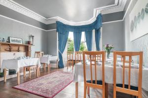 een eetkamer met tafels en stoelen en een raam bij Aynetree Guest House in Edinburgh