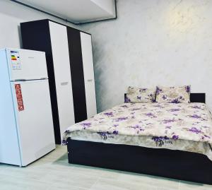 Schlafzimmer mit einem Bett neben einem Kühlschrank in der Unterkunft Ementi Residence in Mamaia Nord – Năvodari