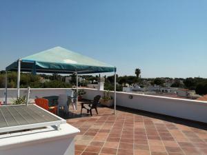 a patio with a blue umbrella on a roof at Montedarena GOLD in Pulsano