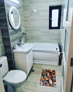 ein Badezimmer mit einem WC, einem Waschbecken und einer Badewanne in der Unterkunft Ementi Residence in Mamaia Nord – Năvodari